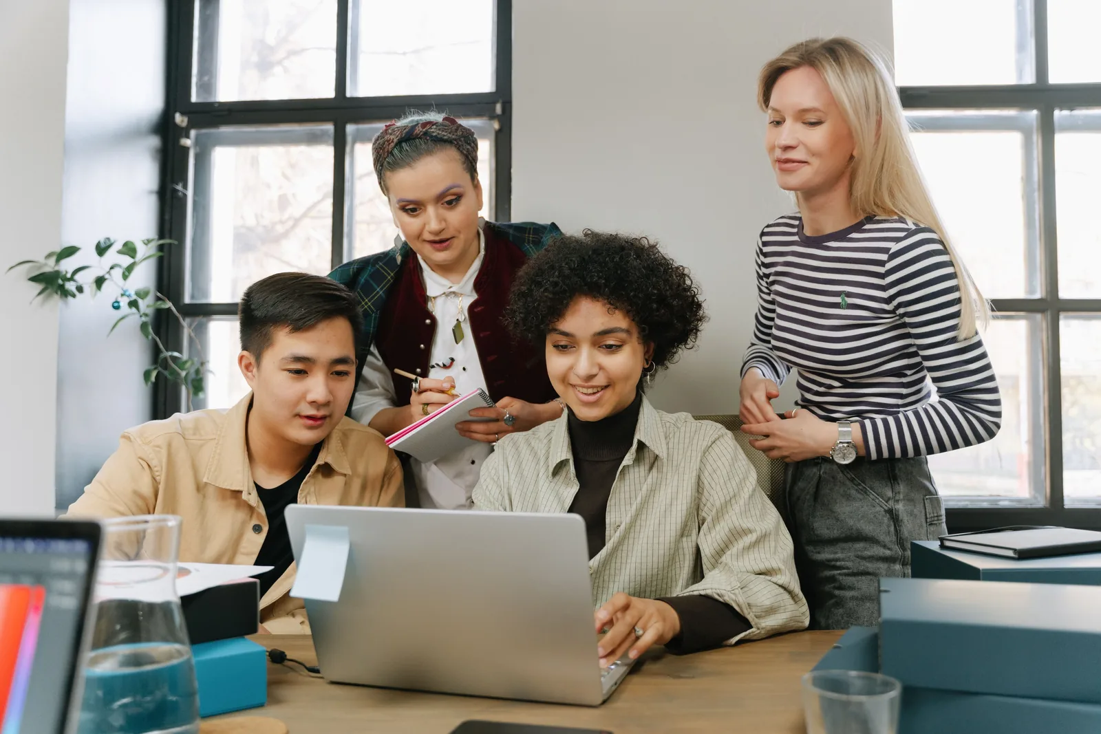 Diverse team reviewing a laptop during a strategy meeting.