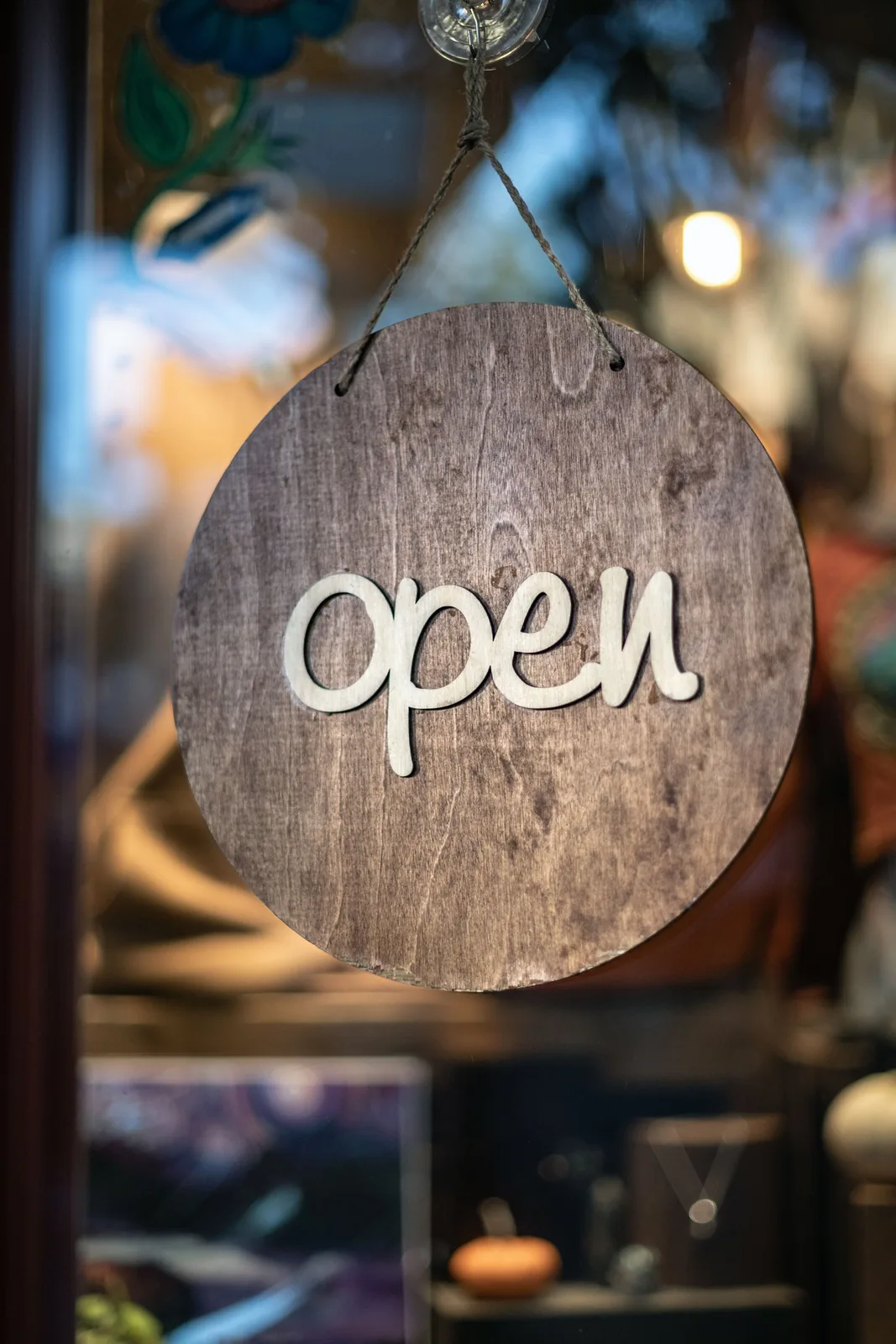 Wooden open sign hanging at a small business entrance.