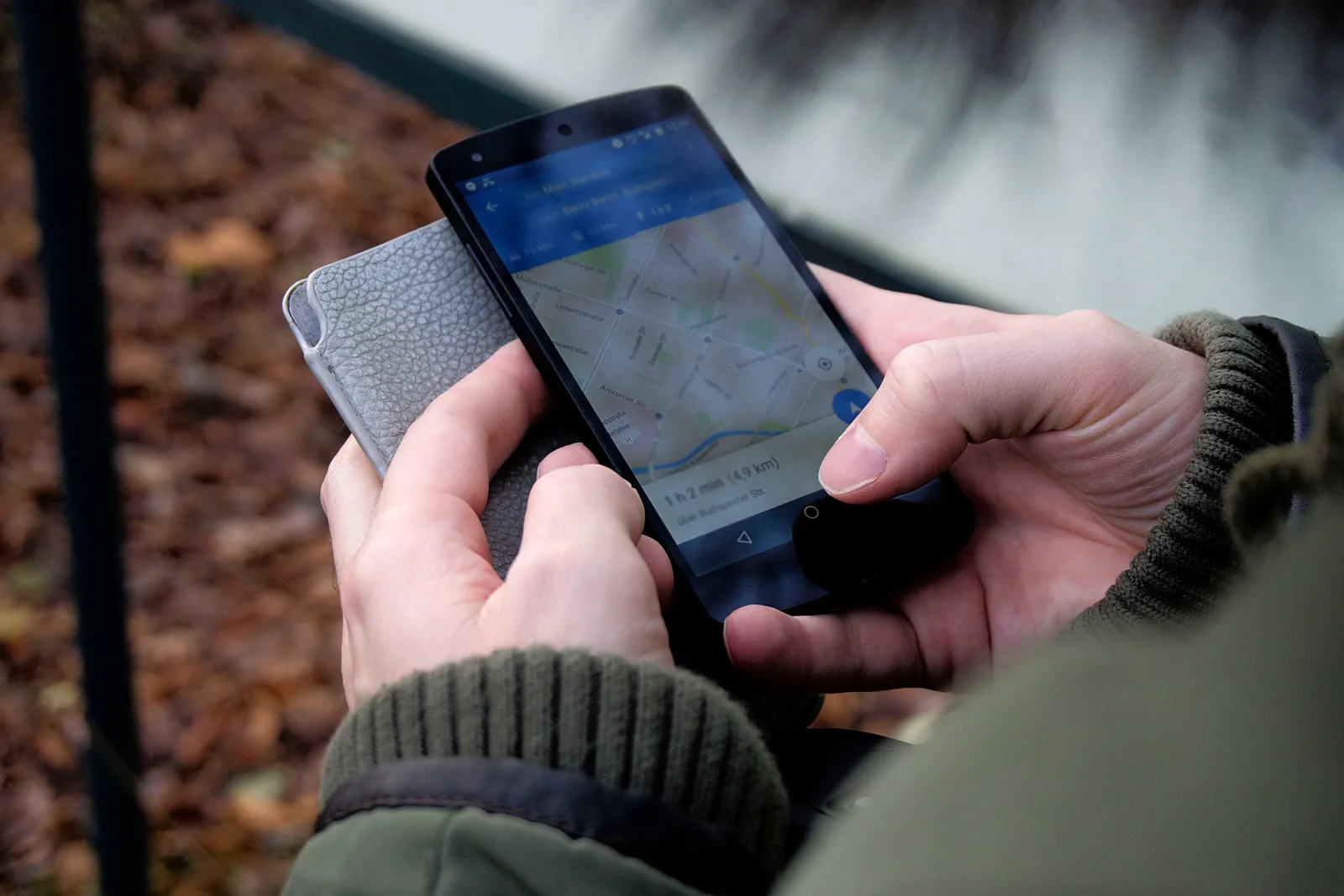 Hands using a smartphone map for local navigation.