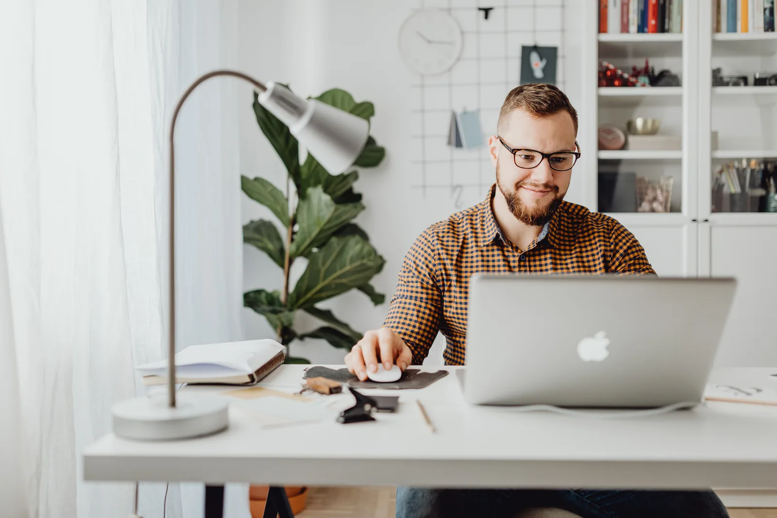 Professional working at a laptop in a home office.
